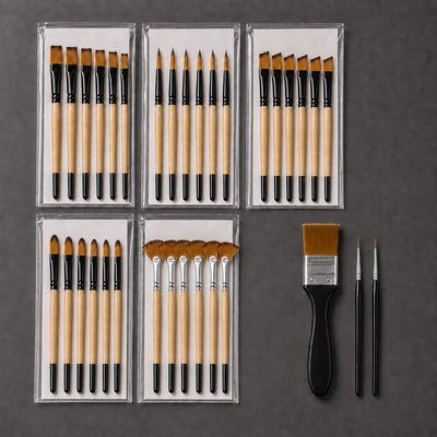 The complete thirty-three piece brush set on a graphite background: five sealed sleeves of six brushes each, one wide three-centimetre flat brush with a black handle, and two fine detail brushes.