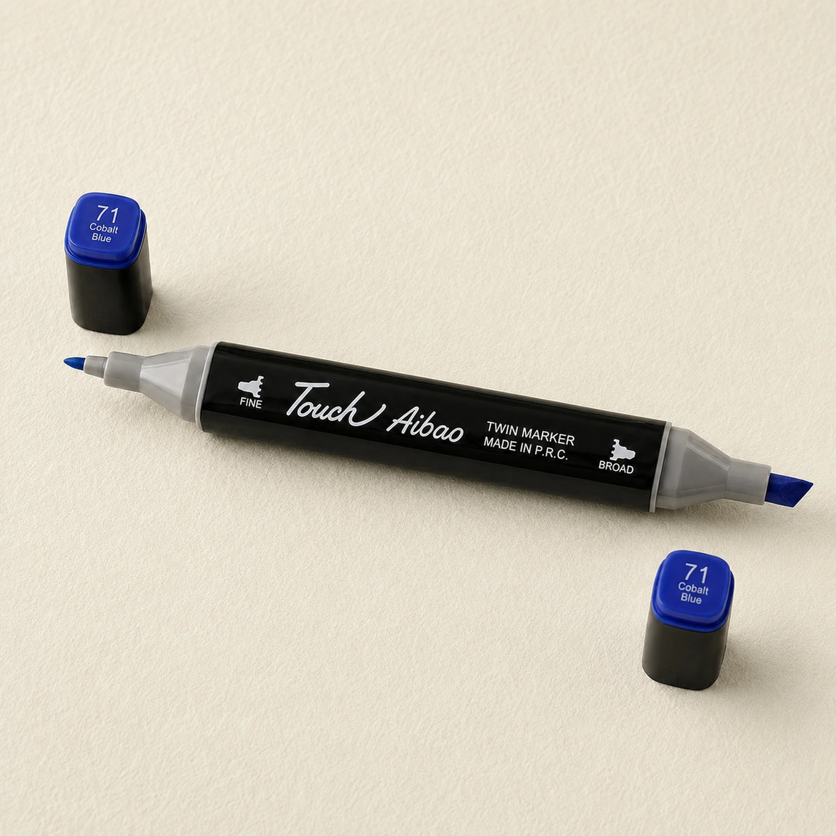 Single twin alcohol marker in Cobalt Blue, caps off, showing the broad chisel nib and the fine bullet nib