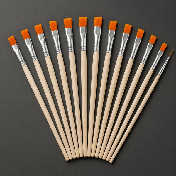 Thirteen short-handled brushes fanned out on a graphite background, twelve flat and one fine liner, with unvarnished pale wood handles, silver ferrules and orange filament.