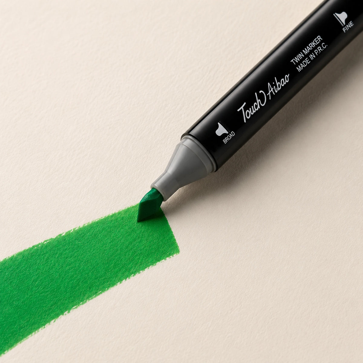 Broad chisel nib of a Touch Aibao marker laying a wide 46 Vivid Green stroke across ivory art paper