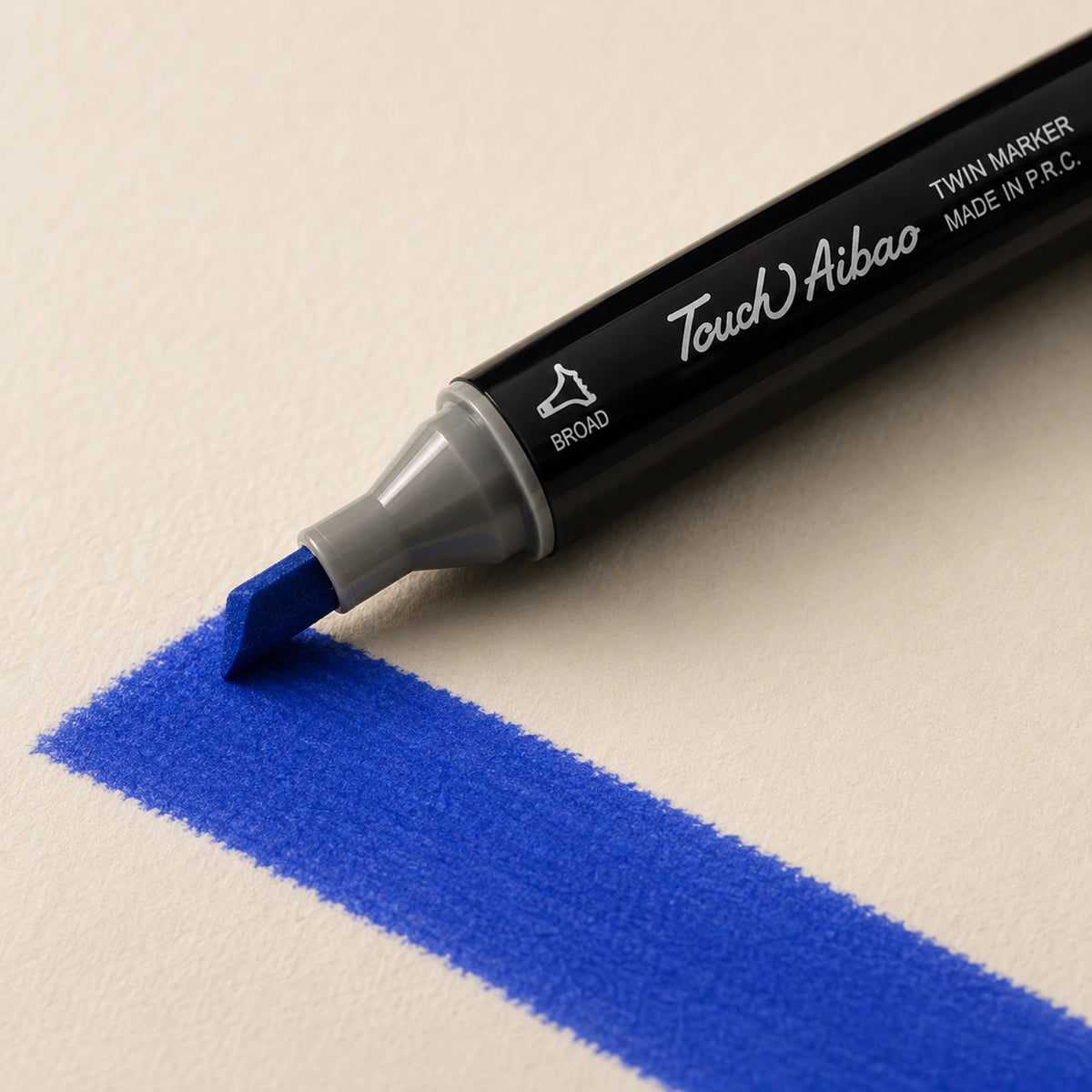 Broad chisel nib of a Touch Aibao marker laying a wide 70 Royal Blue stroke across ivory art paper