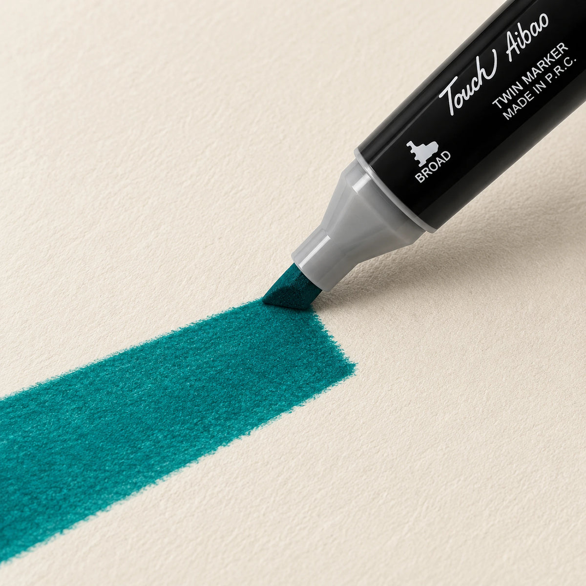 Broad chisel nib of a Touch Aibao marker laying a wide Peacock Green stroke across ivory art paper