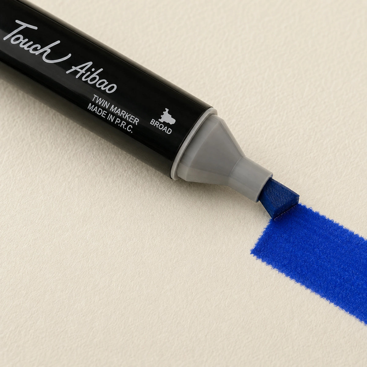 Broad chisel nib laying a wide Cobalt Blue alcohol marker stroke across ivory art paper