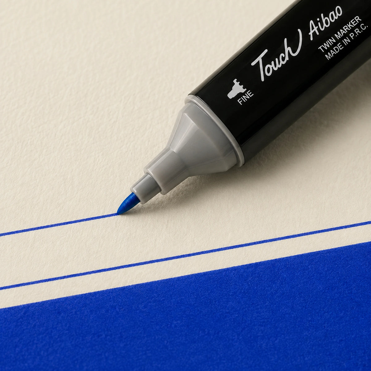 Fine bullet nib drawing a crisp thin Cobalt Blue alcohol marker line on ivory art paper